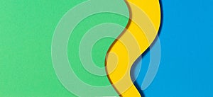 Abstract color papers geometry flat lay composition banner background with blue, yellow and green color tones