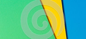 Abstract color papers geometry flat lay composition banner background with blue, yellow and green color tones