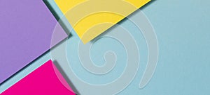 Abstract color papers geometry flat lay composition banner background with purple, yellow, magenta and blue color tones