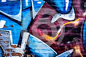 Urban abstract graffiti art background on brick wall with colors of blue white red rust and gray