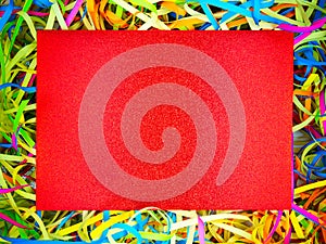 Abstract colorful holiday paper ribbons,red rectangle sparkling paper copy space in middle.Celebration curly serpentine