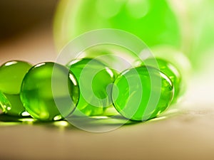 Abstract composition with beautiful, green, round jelly balls on an aluminium foil with reflexions