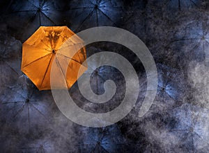 abstract concept of leader with with many dark and a orange umbrella.