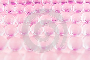 Abstract cosmetic background -  glass balls wit purple color on pastel pink backdrop.