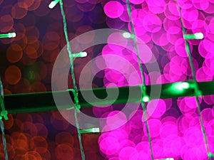 Abstract Dark Bokeh light blurred background, lightbulb on Christmas tree for celebrate season with pink, red and green colorful