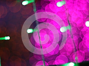 Abstract Dark Bokeh light blurred background, lightbulb on Christmas tree for celebrate season with pink, red and green colorful