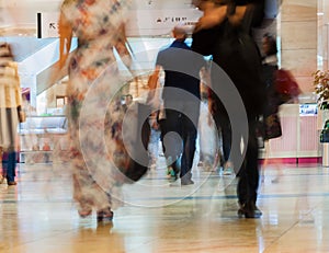 Abstract defocused motion blurred walking young men and women in the shopping center, urban lifestyle concept