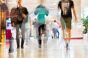 Abstract defocused motion blurred young people walking in the shopping center, urban lifestyle concept, background.