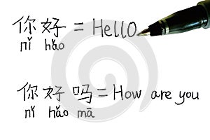 Handwritten Chinese text with pinyin and its English translation of Hello and How Are You with a pen photo