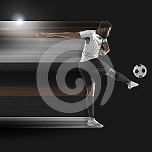 Abstract desing, concept of sport, action, motion in sport. Young african football, soccer player in neon light on black