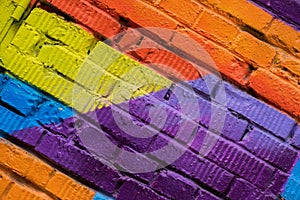 Abstract detail of brick wall with fragment of colorful graffiti, street art closeup. For backgrounds. Modern iconic