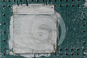 Abstract, detail of an old, mint green, wooden door with a white painted board