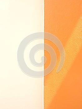 Abstract diagonal shadow on white and orange cement wall