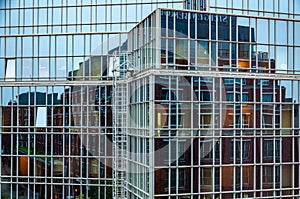 Abstract distorted reflection of house in mirrored glass wall of modern corporate building
