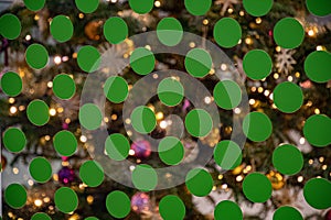 Abstract dotted background with green dots on glass surface and blurred shine golden lights of Christmas tree behind. Repeate