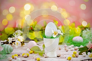 Abstract easter greeting card, with white egg on colorful floral background with bokeh lights