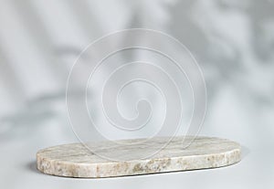 Abstract empty marble board with shadows leaves on a gray background. Layout concept for promotional product presentation, sale or