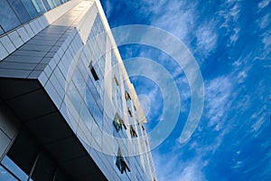 abstract facade of a modern contemporary finance business building with mirror windows, some of them being opened to let air