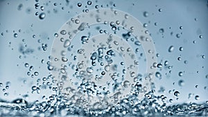 Abstract falling drops of water on a light background close-up