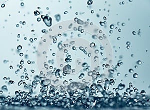 Abstract falling drops of water on a light background close-up