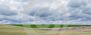 almost abstract fields in countryside of northern france with wind turbine