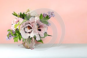 Abstract floral arrangement, home interior with beautiful spring mountain peonies and lilac branches in a vase,