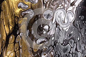 Abstract fluid art background golden and gray colors. Liquid marble. Acrylic painting on canvas with black gradient