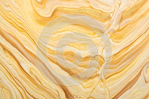 Abstract fluid art background light beige and golden colors. Liquid marble. Acrylic painting with yellow gradient