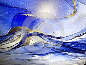 Abstract fluid blue background with gold. Liquid abstraction. Alcohol ink art resembles sea, watercolor or aquarelle.