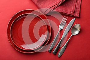 Abstract food background with red plates and cutlery on red table photo