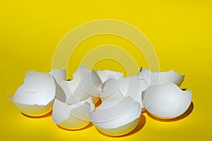 Abstract Food Ingredient. Cracked Eggs Close Up. Broken White Chicken Eggshell. White Eggshell Over Yellow Background.