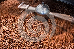 Abstract freshly roasted coffee beans background. Slow motion in the cooler