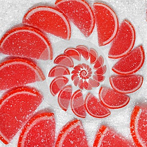 Abstract fruit jelly wedges red cantle lobule on white sugar background. Red jellies. Abstract fruit jelly on white sugar backgrou