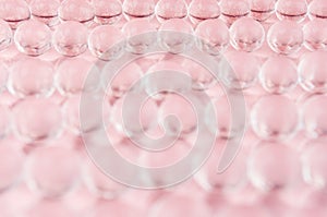 Abstract gentle pink background -  transparent glass balls on pastel backdrop, blur.