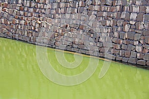 Abstract geometric background with green water and gray brick wall. Diagonal wallpaper texture background