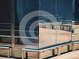 Abstract geometric background. Shiny silver-colored metal pipes and a brown stone floor are reflected in the dark stone mirror