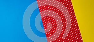 Abstract geometric blue, yellow and red polka dot paper background.