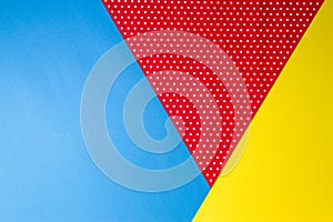 Abstract geometric blue, yellow and red polka dot paper background.