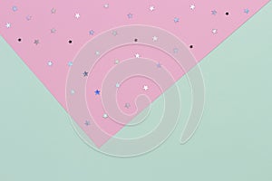 Abstract geometric festive background. Light green and pastel pink with glitter stars paper background. Top view