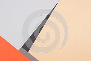 Abstract geometric paper background. Orange, light gray, black and brown craft paper flat lay. Top view