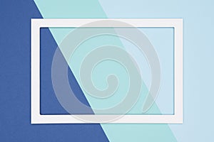 Abstract geometrical flat lay pastel blue and turquoise colored paper background. Minimalism template with empty picture frame.