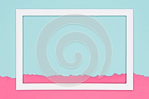 Abstract geometrical pastel blue and pink colored paper flat lay background. Minimalism template with empty picture frame.