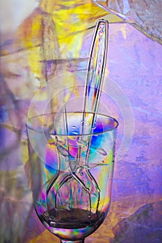 An abstract with glass and cutlery showing light refraction and rainbow colors