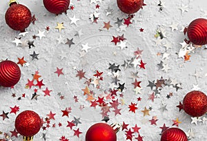 Abstract glittered Christmas background with red baubles over white board. Copy space