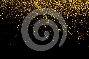 Abstract gold defocused glitter holiday background on black. Falling shiny sparkles. New year Christmas glowing backdrop