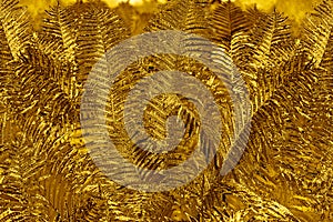 Abstract golden fern leaves background close up, fantastic gold colored bracken foliage texture, decorative yellow frond leaf