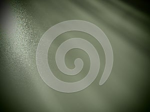 Abstract green background. Oblique light rays on a gray background with flickering dots. From left to top, the lines are