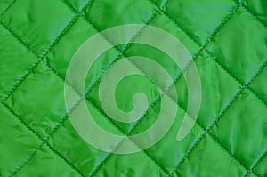 Abstract green fabric texture quare seam pattern.Guilted jacket.Empty background for design with copy space.