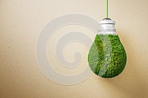 Abstract green grass light bulb on brown background with mock up place. Eco concept and energy concept.