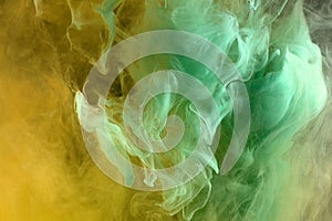 Abstract green and orange color background. Swirling vibrant hookah smoke, dynamic paint in water